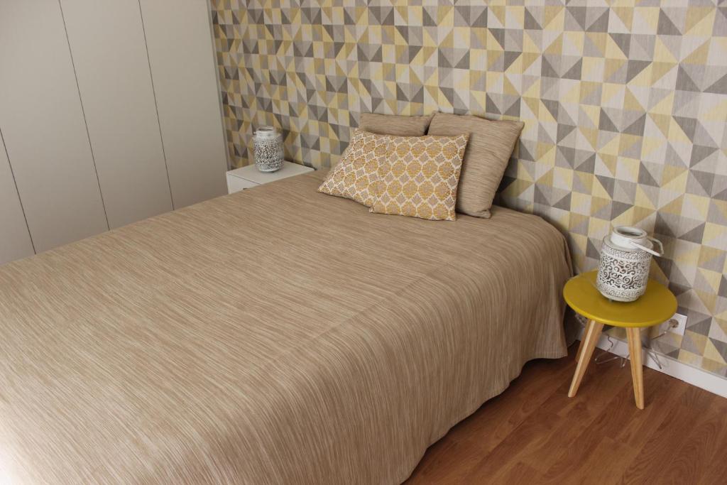 a bedroom with a bed and a yellow table at Casa da Azarujinha in Estoril
