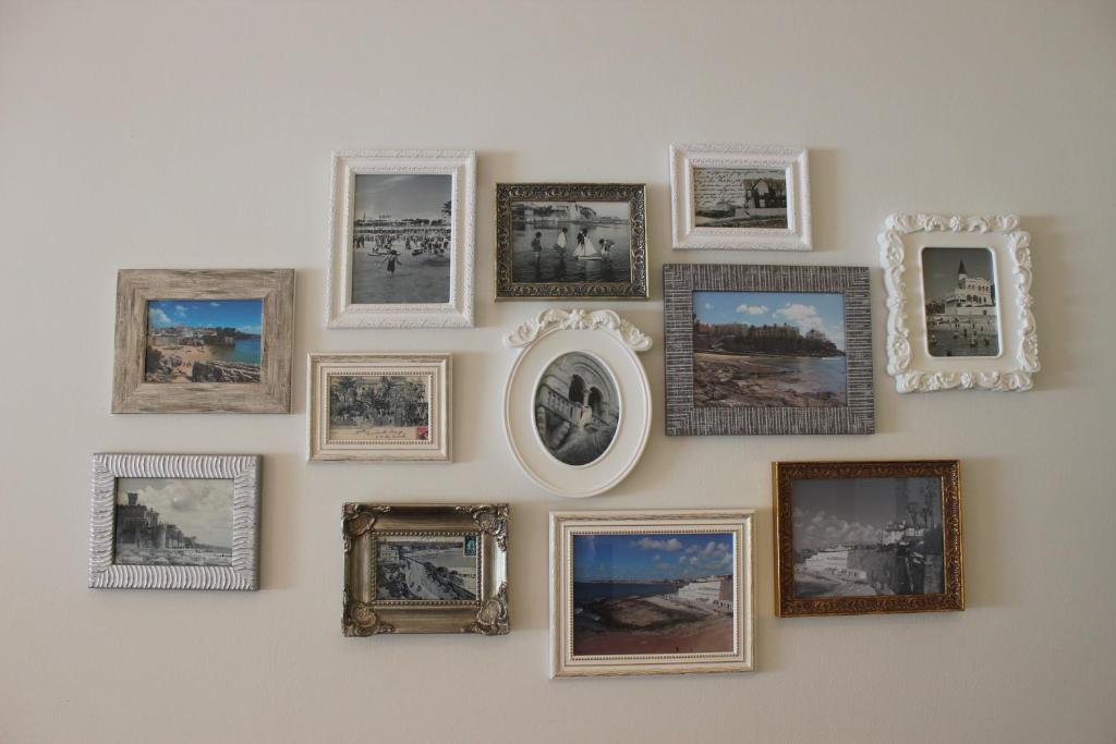 a wall with framed pictures on a wall at Casa da Azarujinha in Estoril