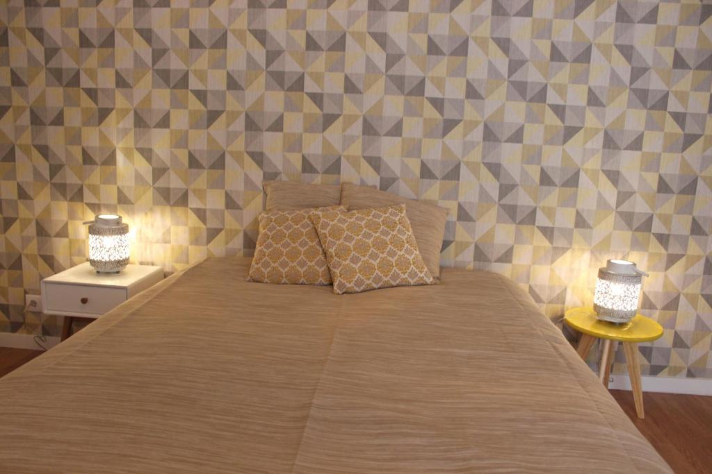 a bedroom with a bed with two lamps on it at Casa da Azarujinha in Estoril