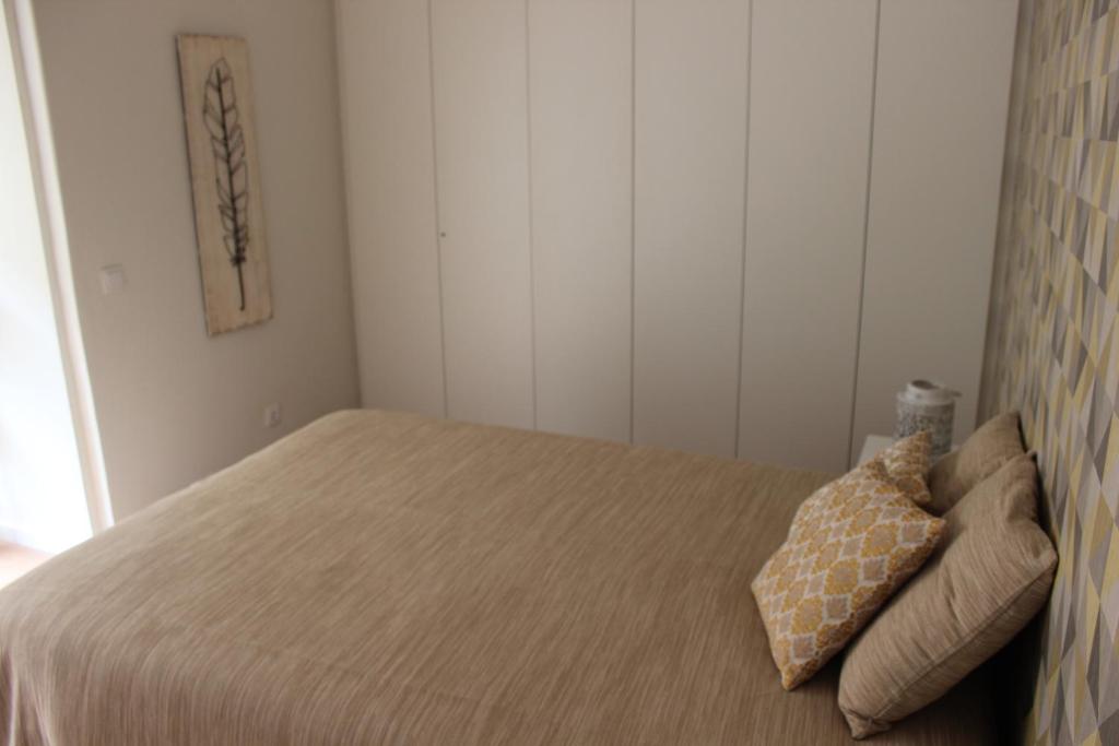 a small bedroom with a bed with two pillows at Casa da Azarujinha in Estoril