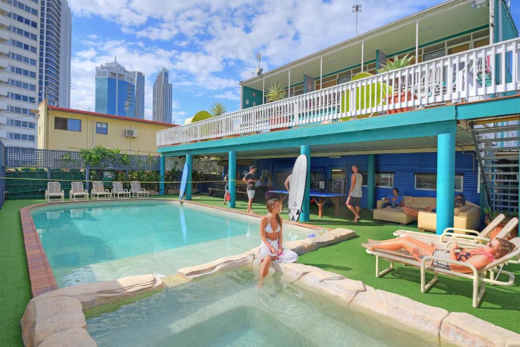 una mujer sentada en una piscina en un hotel en Backpackers In Paradise 18-35 Hostel, en Gold Coast