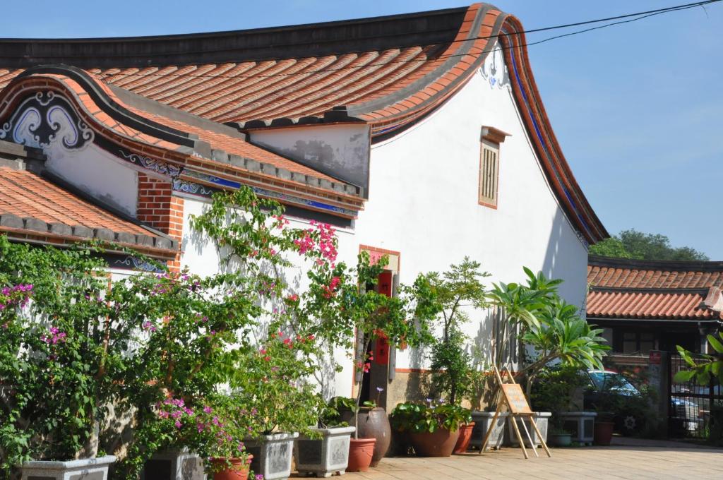 a white building with plants in front of it at Grace Homestay 54 in Jincheng