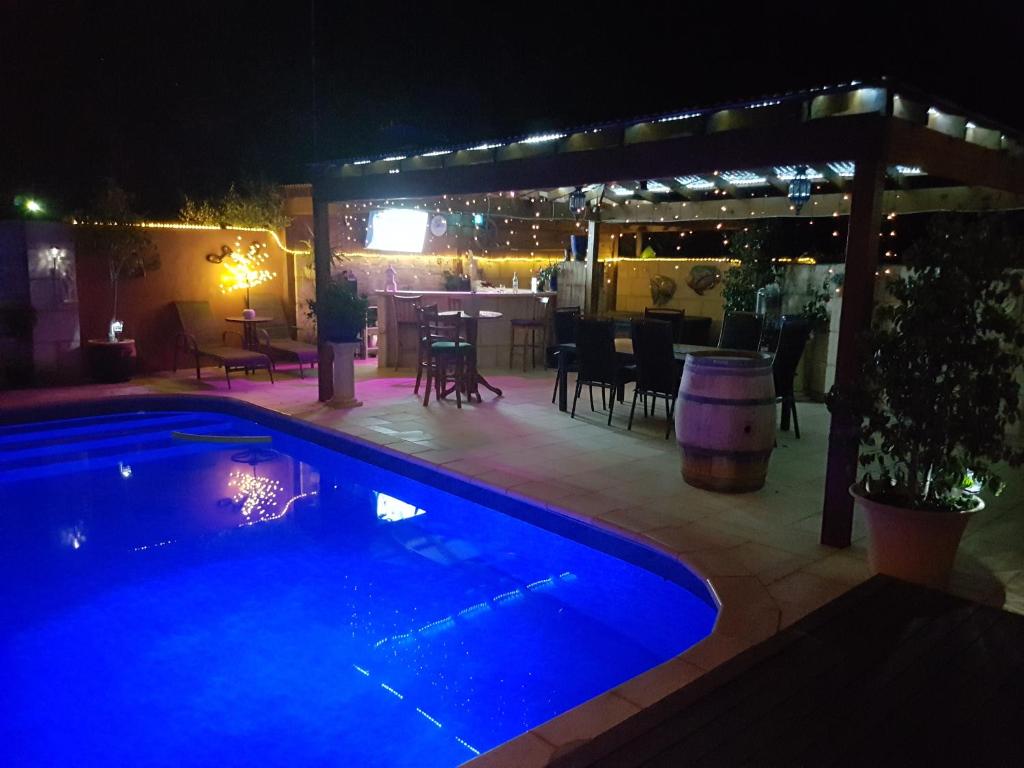 a swimming pool in front of a patio at night at Ocean Reef Homestay in Perth