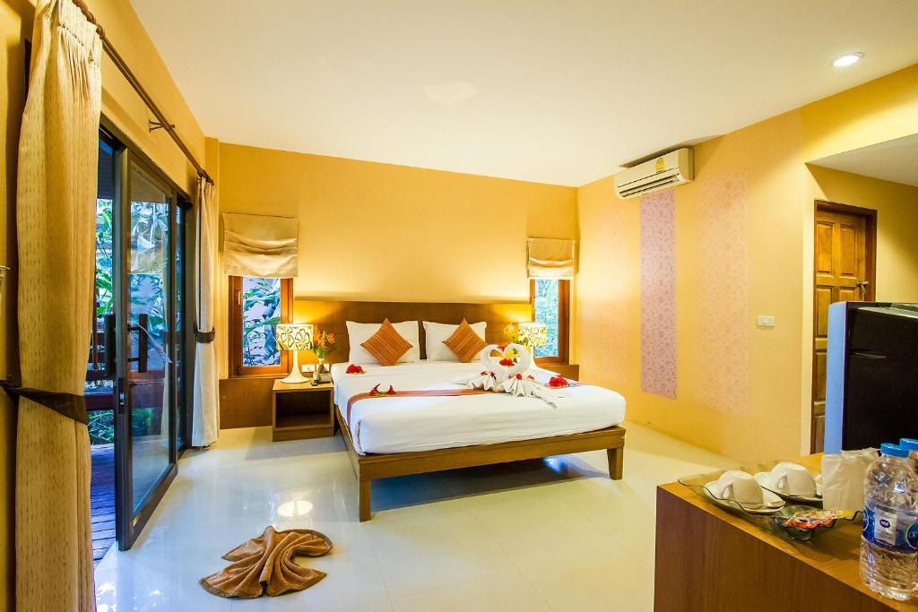 1 dormitorio con 1 cama en una habitación con paredes amarillas en Sunda Resort, en Ao Nang Beach