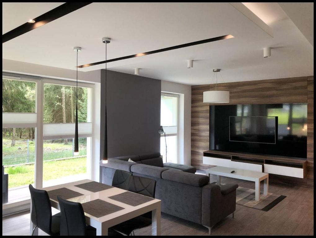 a living room with a couch and a tv at Family Apartment Golden Tulip in Międzyzdroje