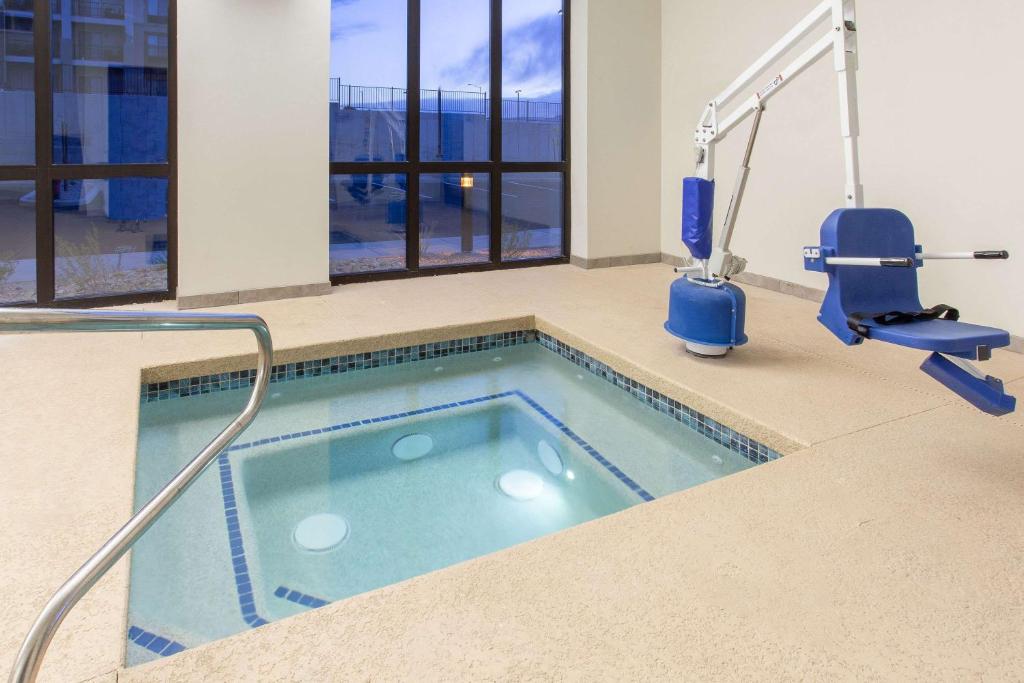 ein Sportschwimmbecken in einem Gebäude mit Stühlen und einem Spa in der Unterkunft Wingate by Wyndham Page Lake Powell in Page