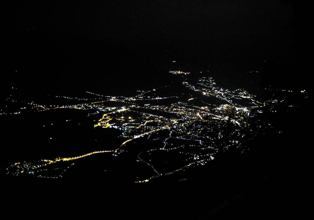 an aerial view of a city at night at Miramonti Boutique Hotel in Avelengo