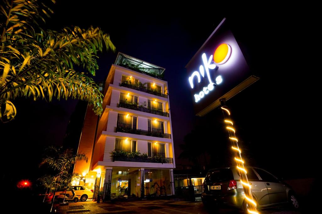 uma placa de hotel iluminada em frente a um edifício em Niko Hotels em Cochin