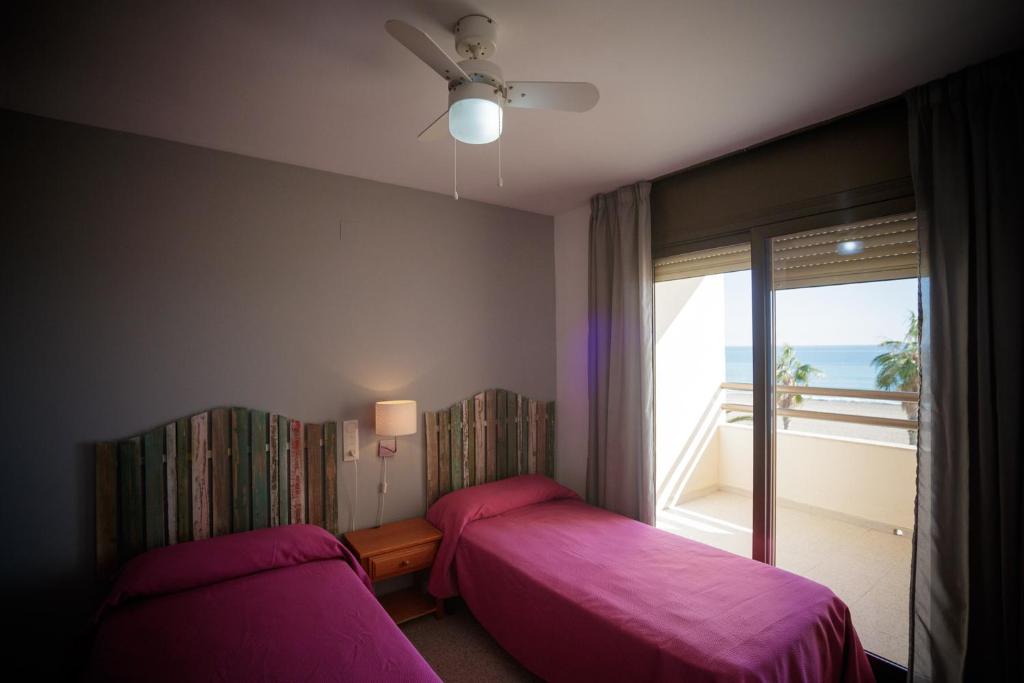 a bedroom with two beds and a window with a view at Apartamentos Florida II in Peñíscola