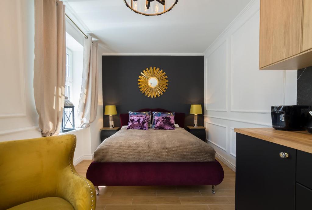 グダニスクにあるBasilica Apartment Mariacka Gdanskのベッドルーム1室(ベッド1台、黄色い椅子付)