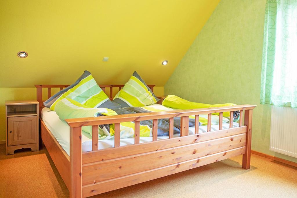 a wooden bed with yellow and blue pillows in a room at Ferienhaus Mara in Borkum