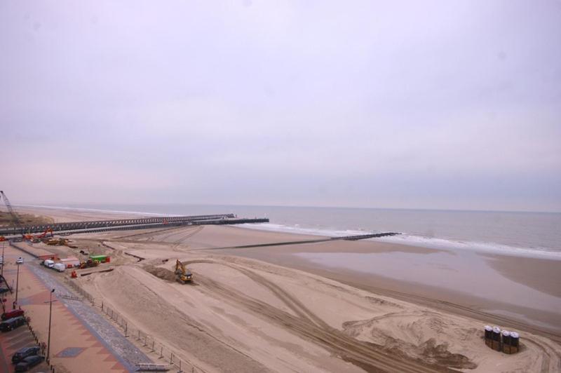 a view of a beach with a bridge and the ocean at Residentie Caraibes, 9de verdieping in Blankenberge