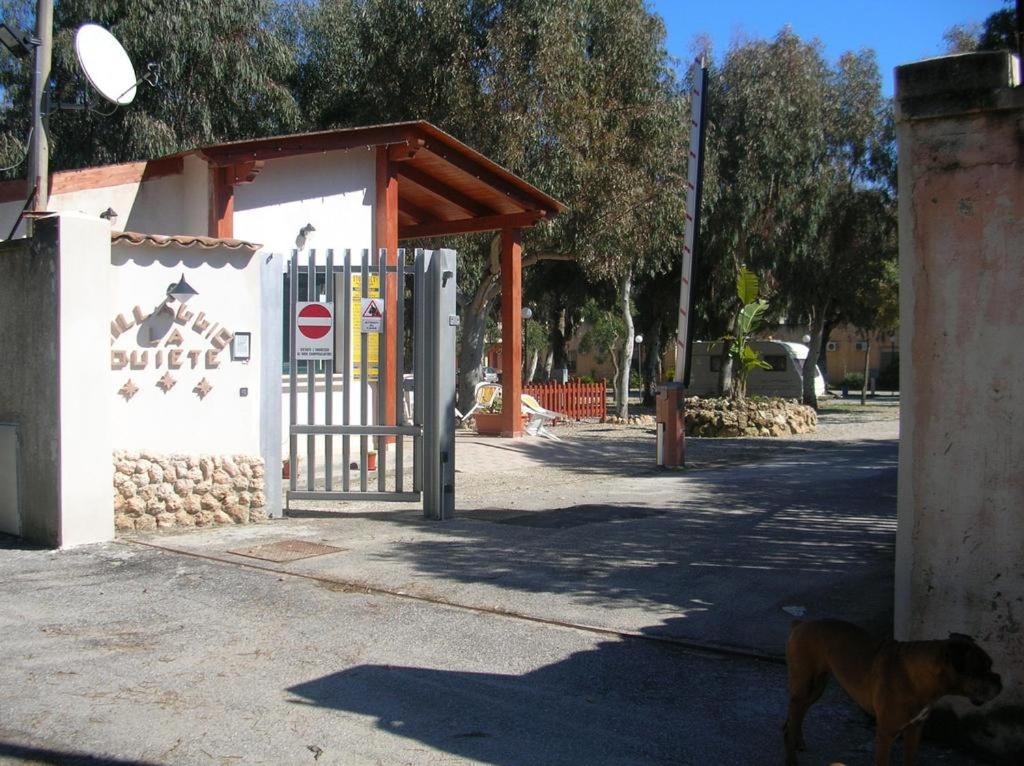 a dog standing next to a gate at a playground at Residence La Quiete in Taureana