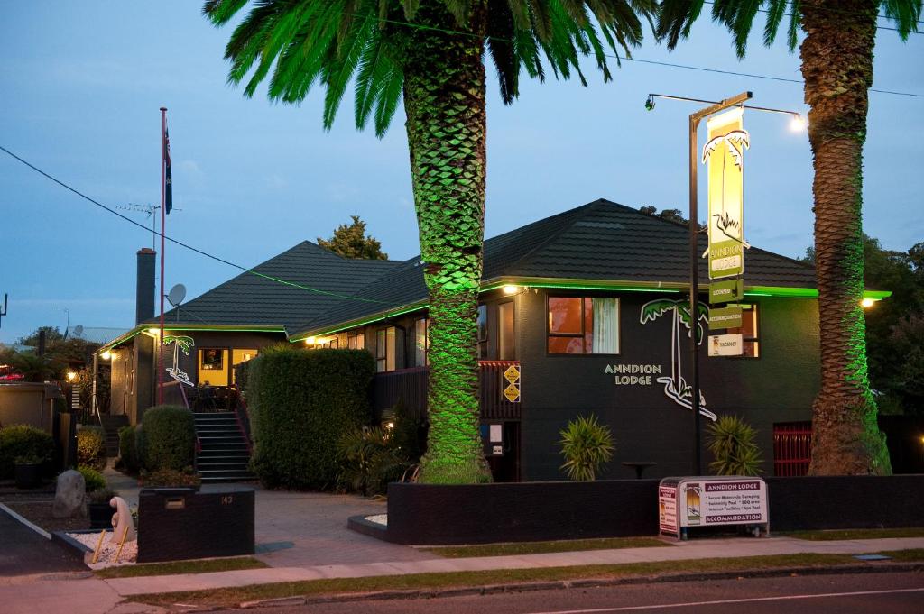 uma casa com duas palmeiras em frente em Anndion Lodge Motel & Conference Centre em Whanganui