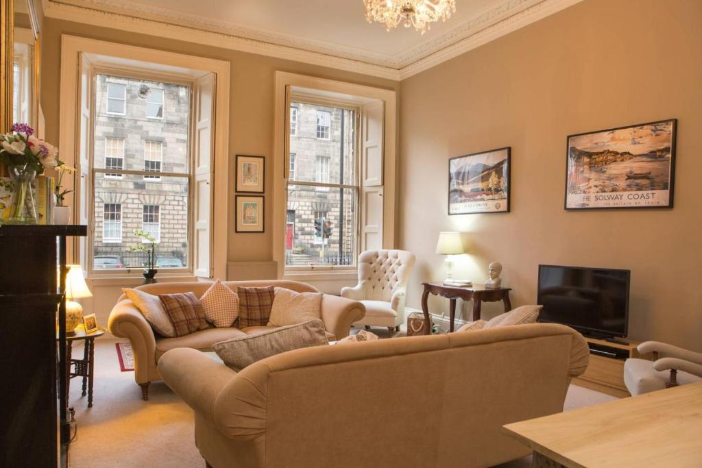 a living room with couches and a tv at ALTIDO Heart of Edinburgh Gem in Edinburgh