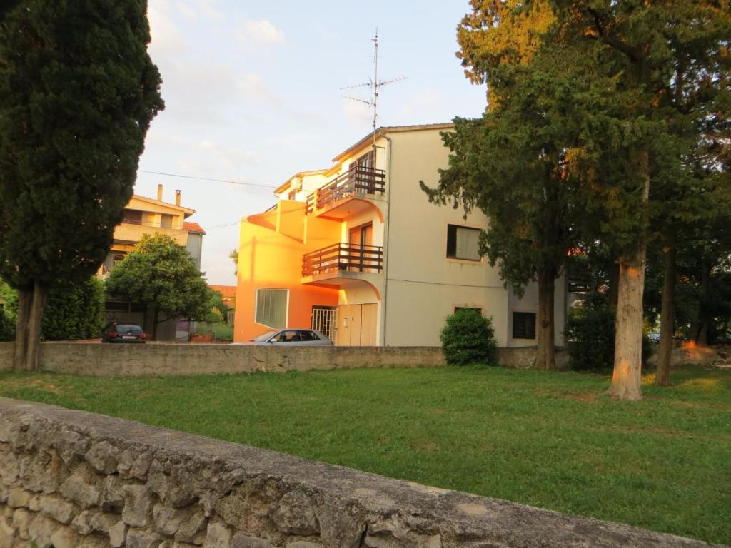 uma casa com uma cerca de pedra em frente em Apartmani Svitlana em Sukošan