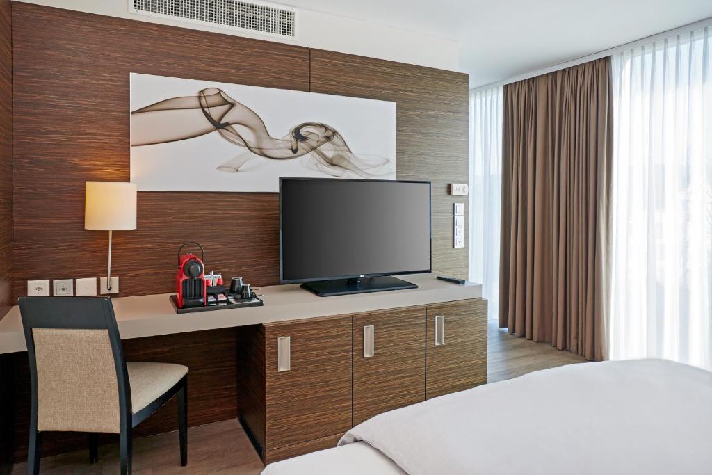 Uma televisão e/ou sistema de entretenimento em H4 Hotel Solothurn