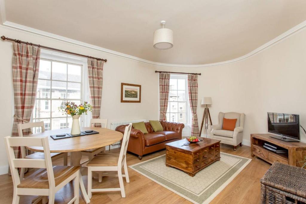 a living room with a table and a couch at ALTIDO Stylish Apartment in Trendy New Town Location in Edinburgh