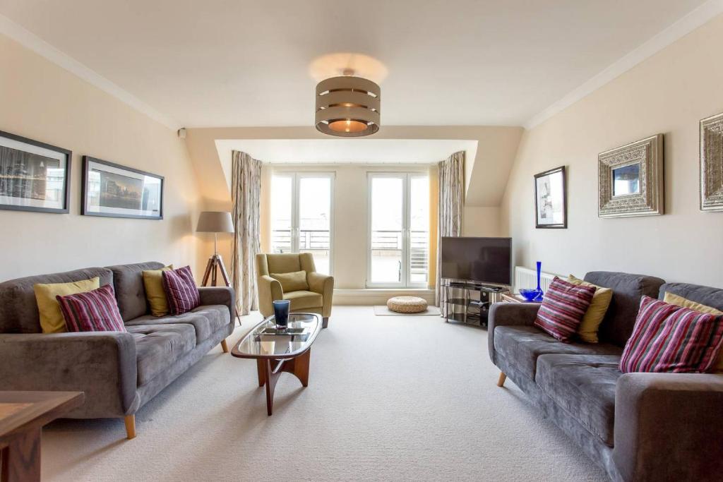 salon z 2 kanapami i telewizorem w obiekcie ALTIDO Homely Apartment near Leith Walk w Edynburgu