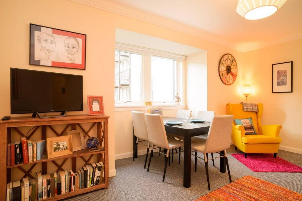 a living room with a dining room table and a television at ALTIDO Lovely Apartment for 4 with Free Parking in Edinburgh