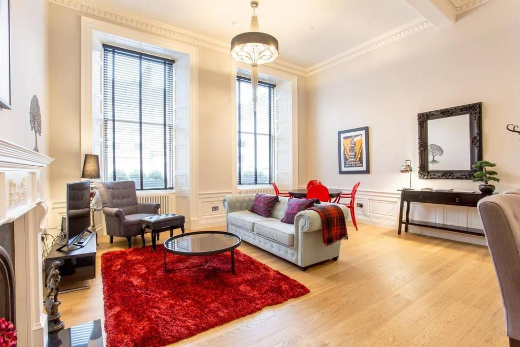 un soggiorno con divano e tappeto rosso di ALTIDO Luxury Retreat in the City Centre for a Great Price a Edimburgo
