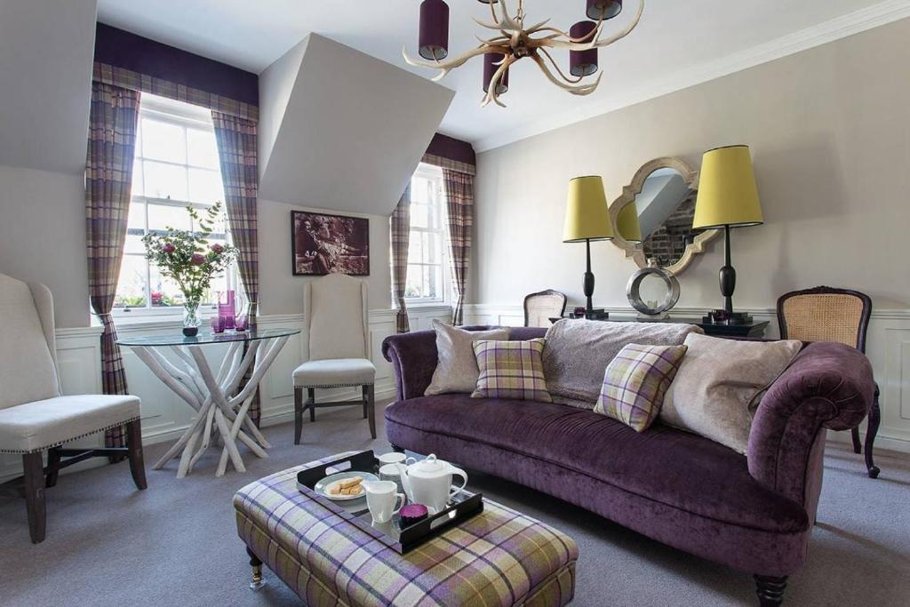 un salon avec un canapé violet et une table dans l'établissement JOIVY Charming Nest for Two with Castle View, à Édimbourg