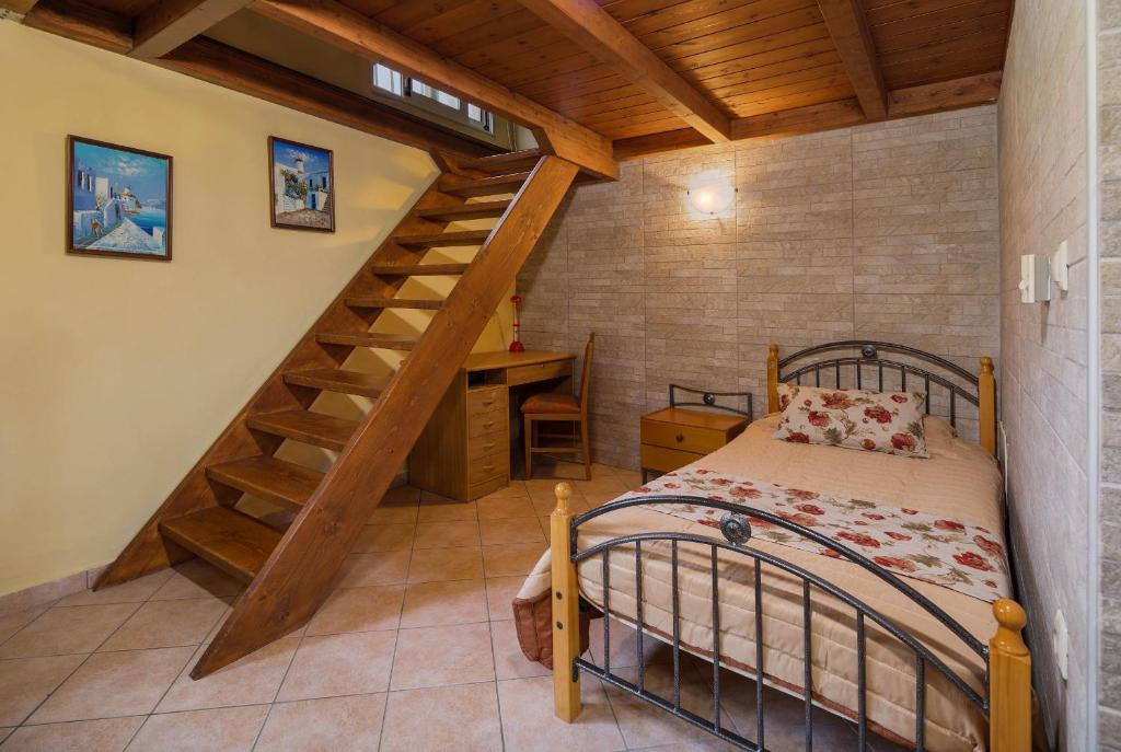 KatastárionにあるMartha's Houseのベッドルーム1室(ベッド1台付)、木製の階段