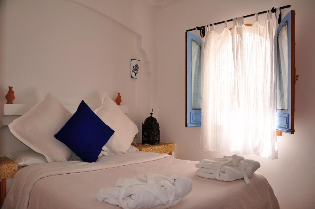a bedroom with a bed with towels on it at Hotel Al Alba Hammam & Restaurant in Asilah