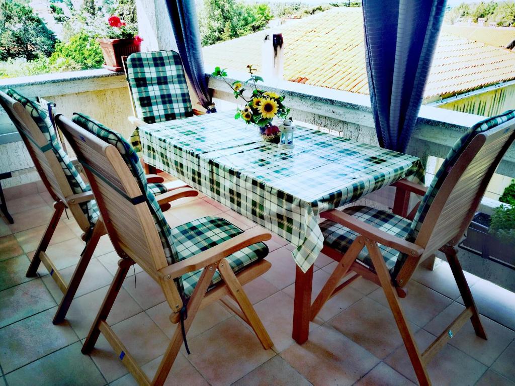 Apartments Boškovićeva في بونات: طاولة وكراسي على شرفة مع طاولة وزهور