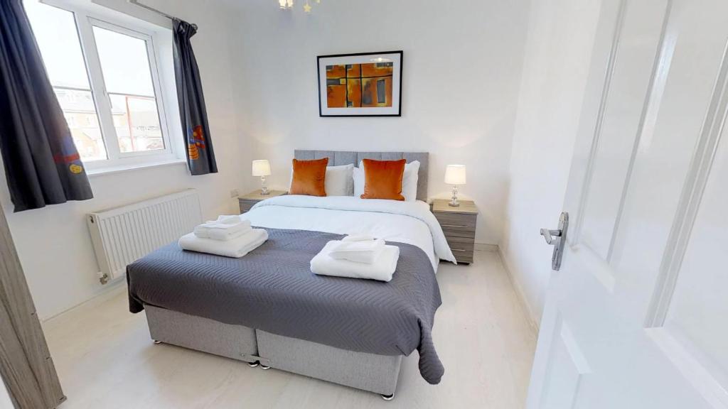 sypialnia z łóżkiem z dwoma ręcznikami w obiekcie StayZo Cole Green Lane Accommodation- FREE Parking w mieście Welwyn Garden City
