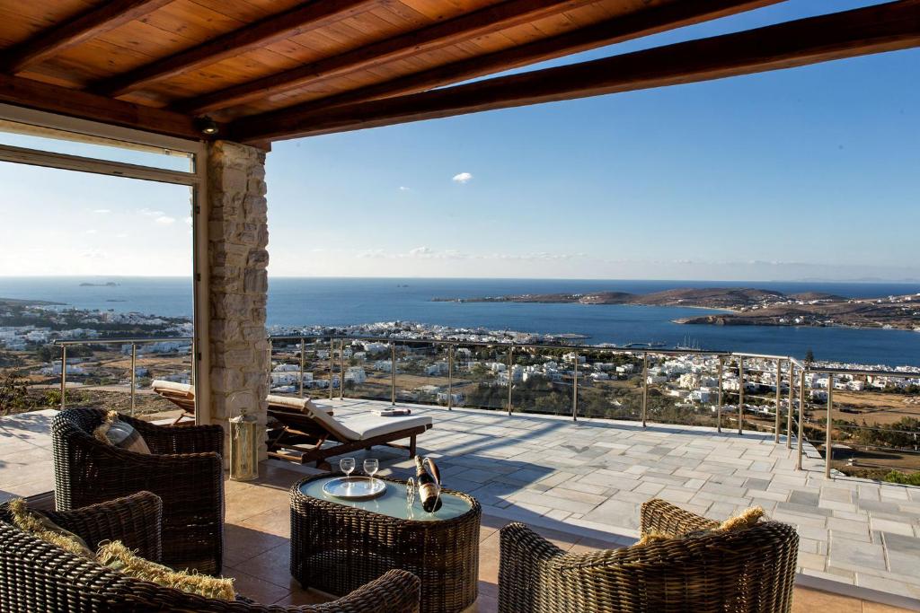 Un balcón con sillas y vistas al océano. en Amazing Sea View Villa, en Parikia