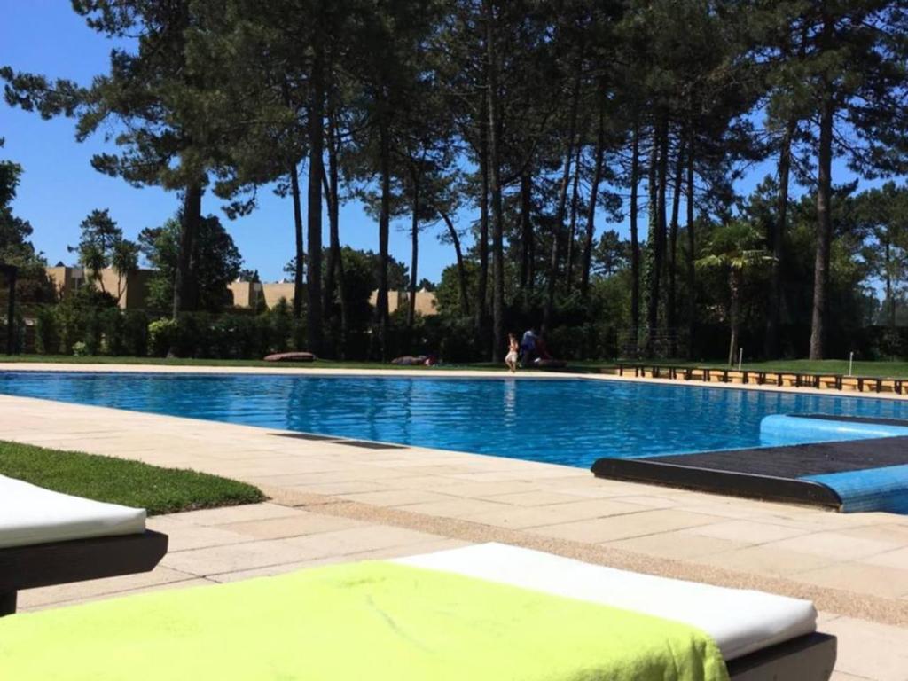uma grande piscina com árvores ao fundo em Moradia em condomínio de luxo em Esposende