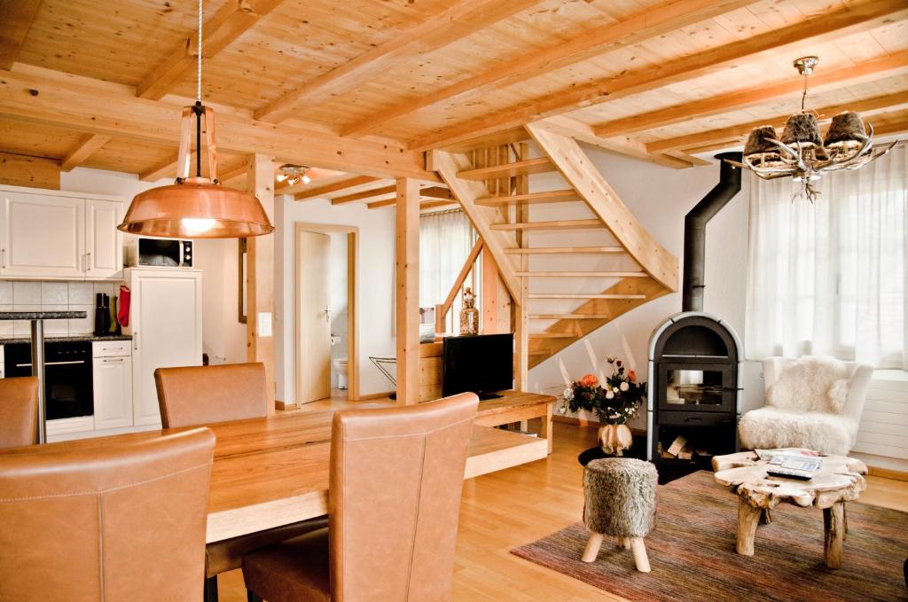 a kitchen and living room with a wood burning stove at Apartment Kiwi links - GRIWA RENT AG in Grindelwald