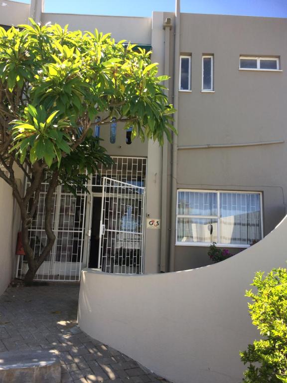 einen Zaun vor einem Gebäude mit einem Tor in der Unterkunft Damara Gardens in Windhoek