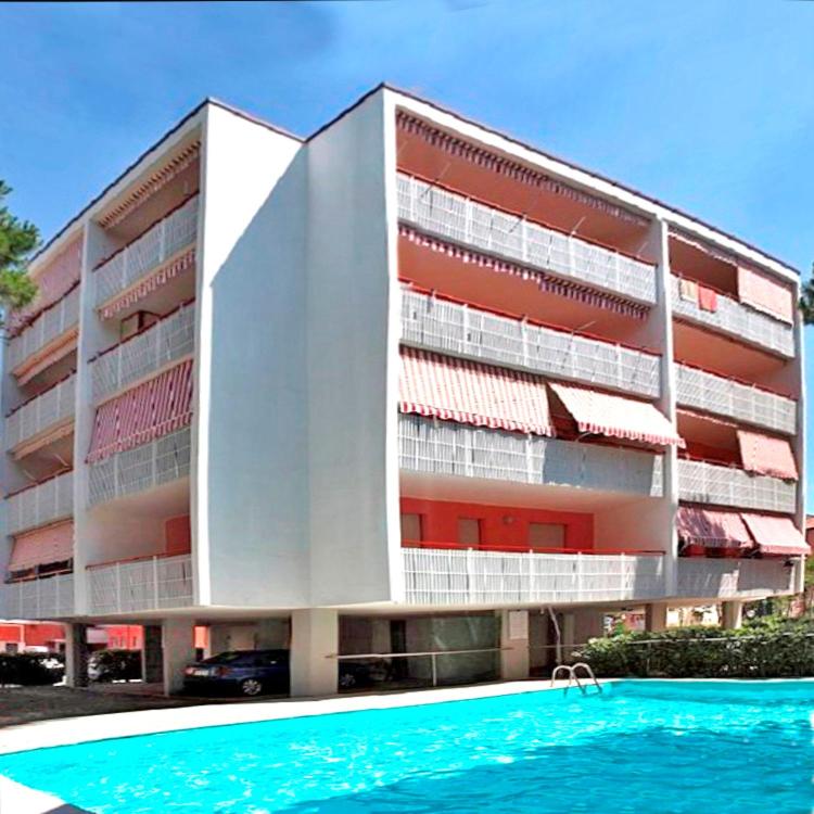 a building with a swimming pool in front of it at Gabbiano Atlante in Bibione