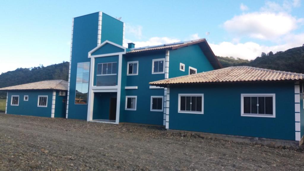 una fila de casas azules con un edificio en el fondo en Pousada Abraço Serrano, en Urubici