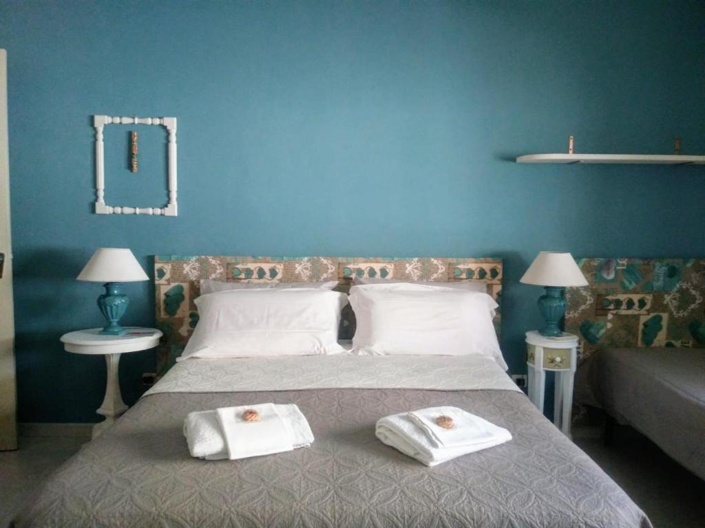 a blue bedroom with a bed with towels on it at Villa Lucia in Syracuse