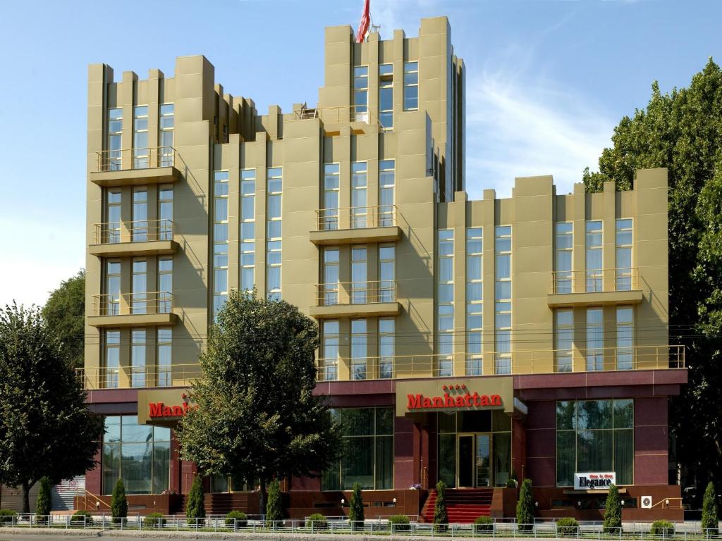 a building with an american flag on top of it at Manhattan Hotel & Restaurant in Chişinău