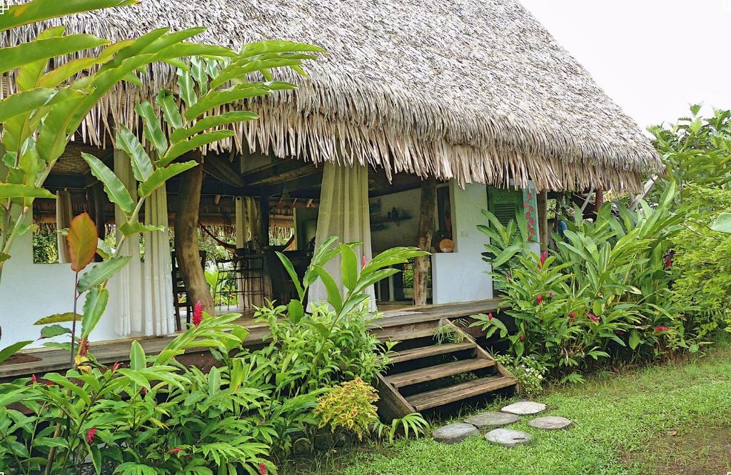 een kleine hut met een grasdak en een trap ernaar toe bij Island Home in Uturoa