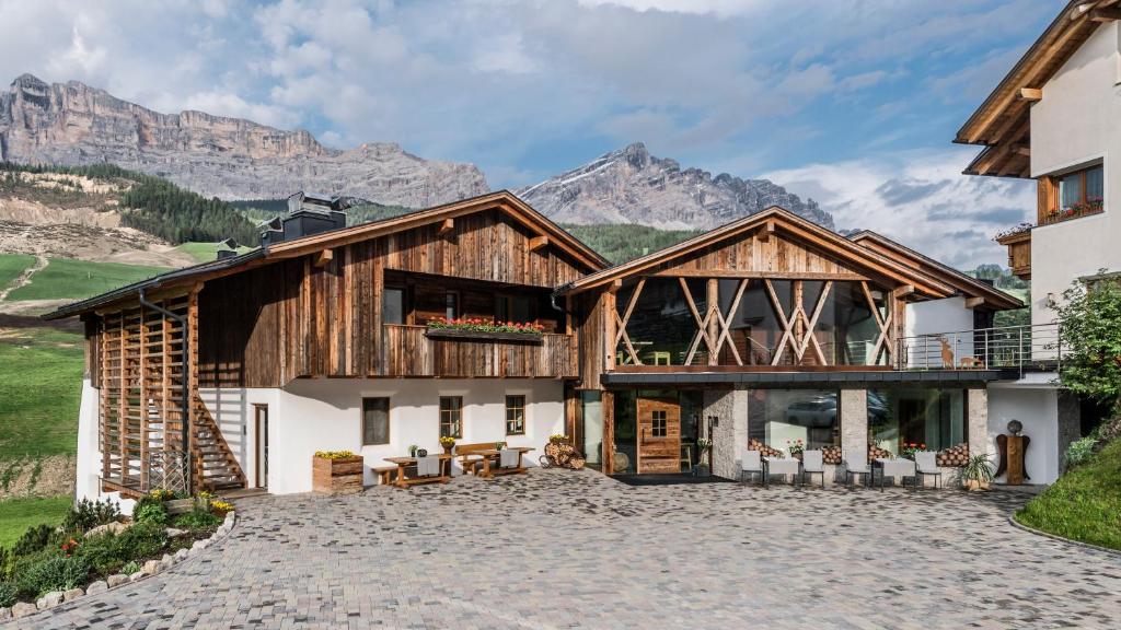 una casa con montagne sullo sfondo di Miraval NaturHotel a Badia