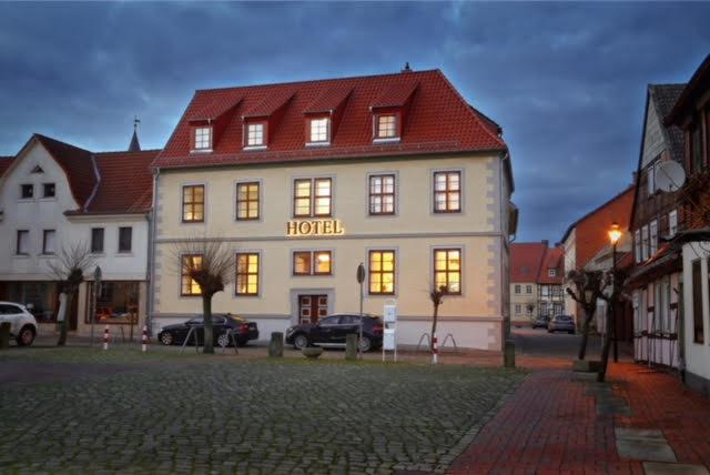 a hotel building with its lights on in a street at Hotel Am Markt in Oebisfelde