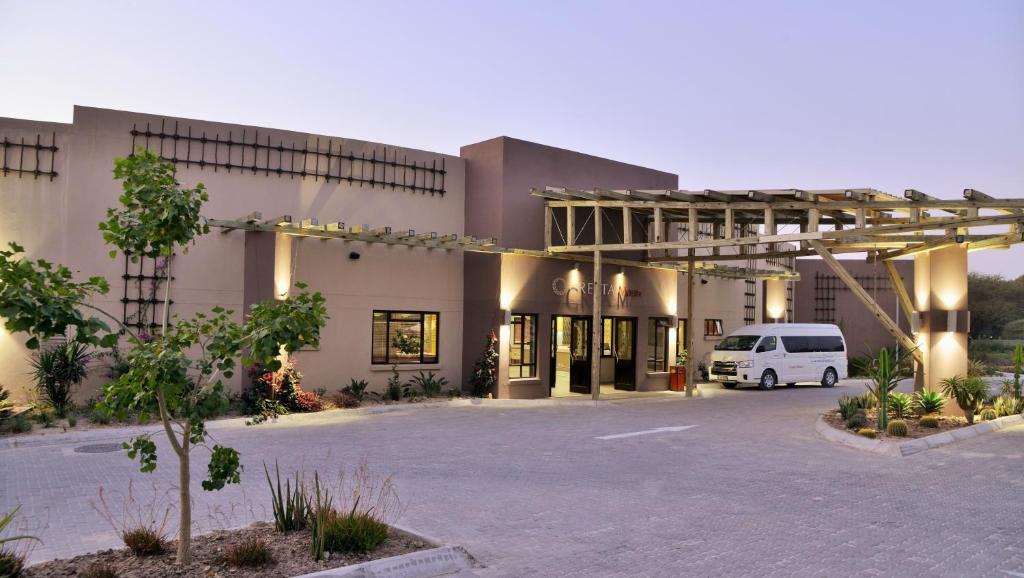 a van parked in a parking lot in front of a building at Cresta Maun Hotel in Maun