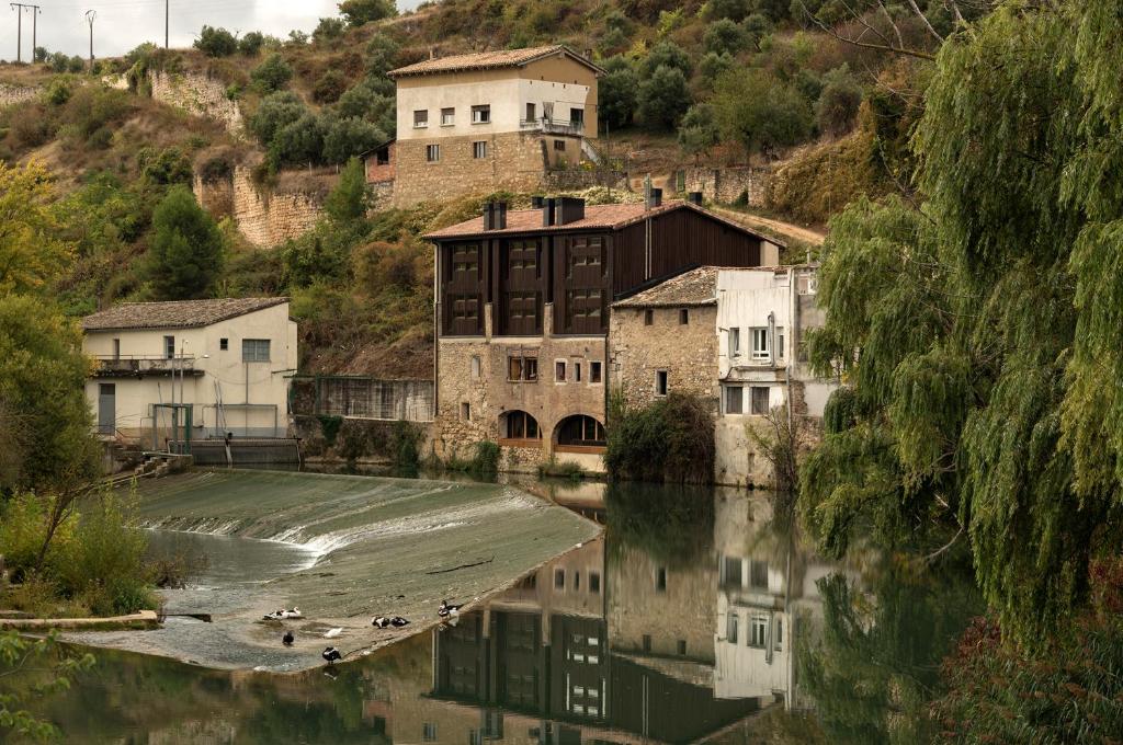 a group of buildings on the side of a river at Hostería de Curtidores in Estella