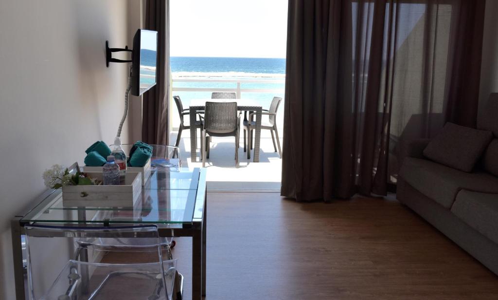 uma sala de estar com uma mesa de vidro e vista para o oceano em Apartamento Primera Línea Playa de Las Canteras em Las Palmas de Gran Canaria