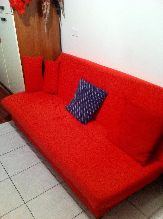 リド・ディ・イエゾロにあるcondominio guanabaraの赤いソファ(赤い枕付)