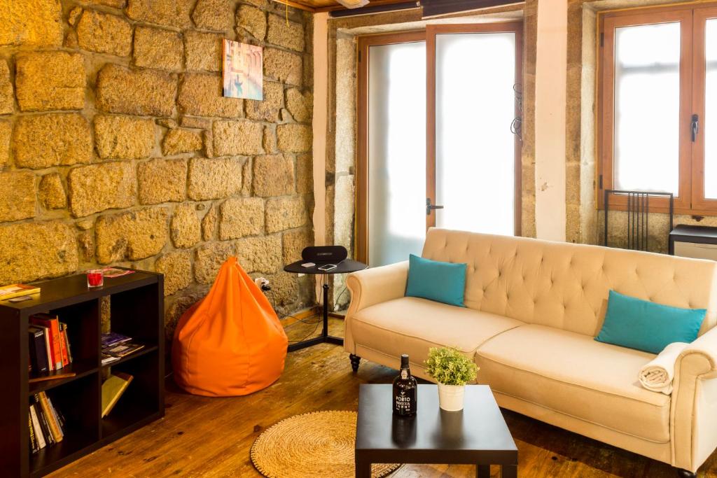 ein Wohnzimmer mit Sofa und Ziegelwand in der Unterkunft Guest H4U - Porto River View in Porto