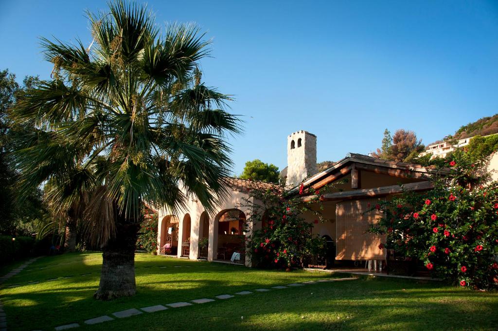 a palm tree in a yard next to a building at Residence Luna Rossa in Costa Rei