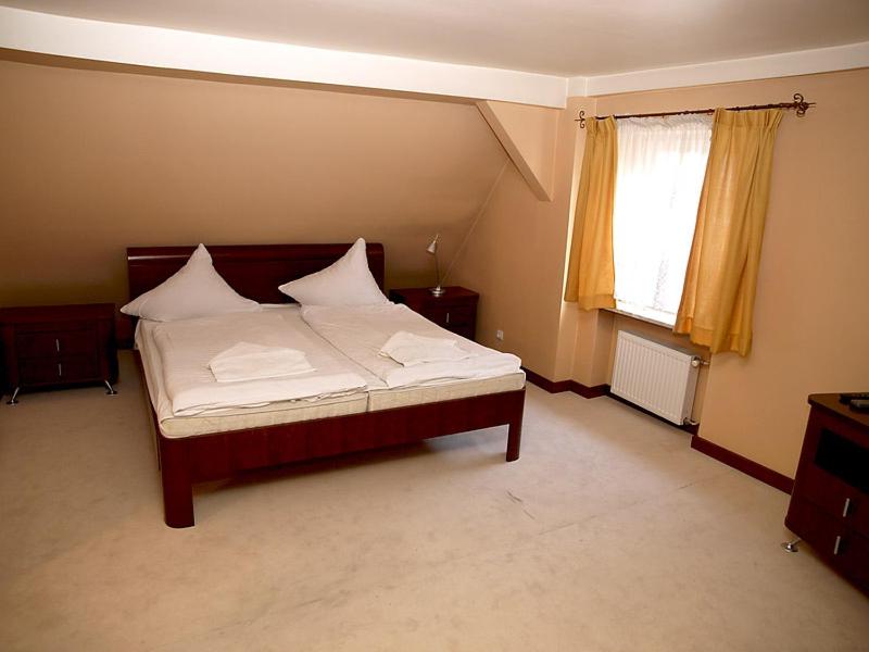 Hotel Polonia في نوا سول: غرفة نوم بسرير وملاءات بيضاء ونافذة