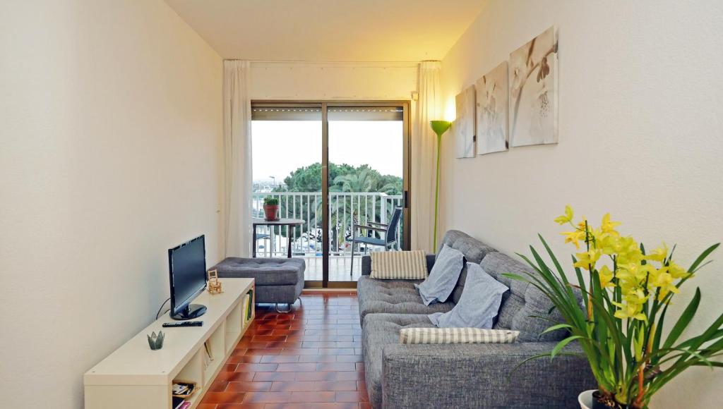 sala de estar con sofá y TV en Apartamento Puerto Miramar, en Cambrils