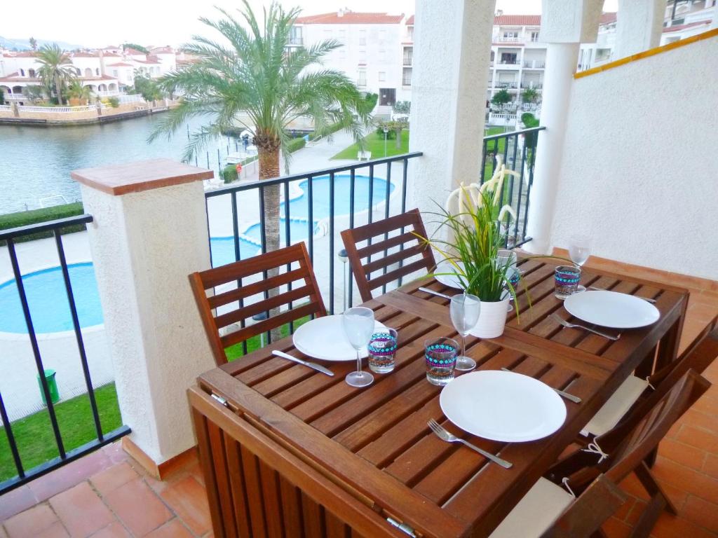 エンプリアブラバにあるApart-rent Apartment Sant Maurici 0137の木製テーブル、水辺の景色を望むバルコニー